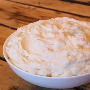 Bowl of creamy mashed potatoes on table