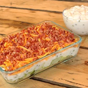 Layered bacon and cheese dip in glass dish