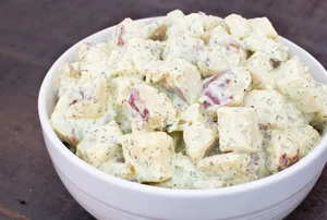 Creamy potato salad with herbs in bowl