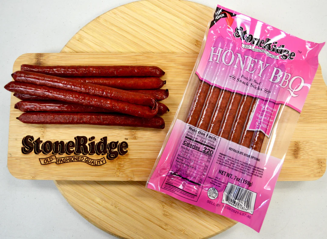 Honey BBQ meat sticks on wooden cutting board