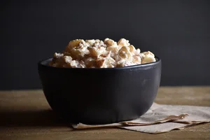 Black bowl of popcorn on wooden table